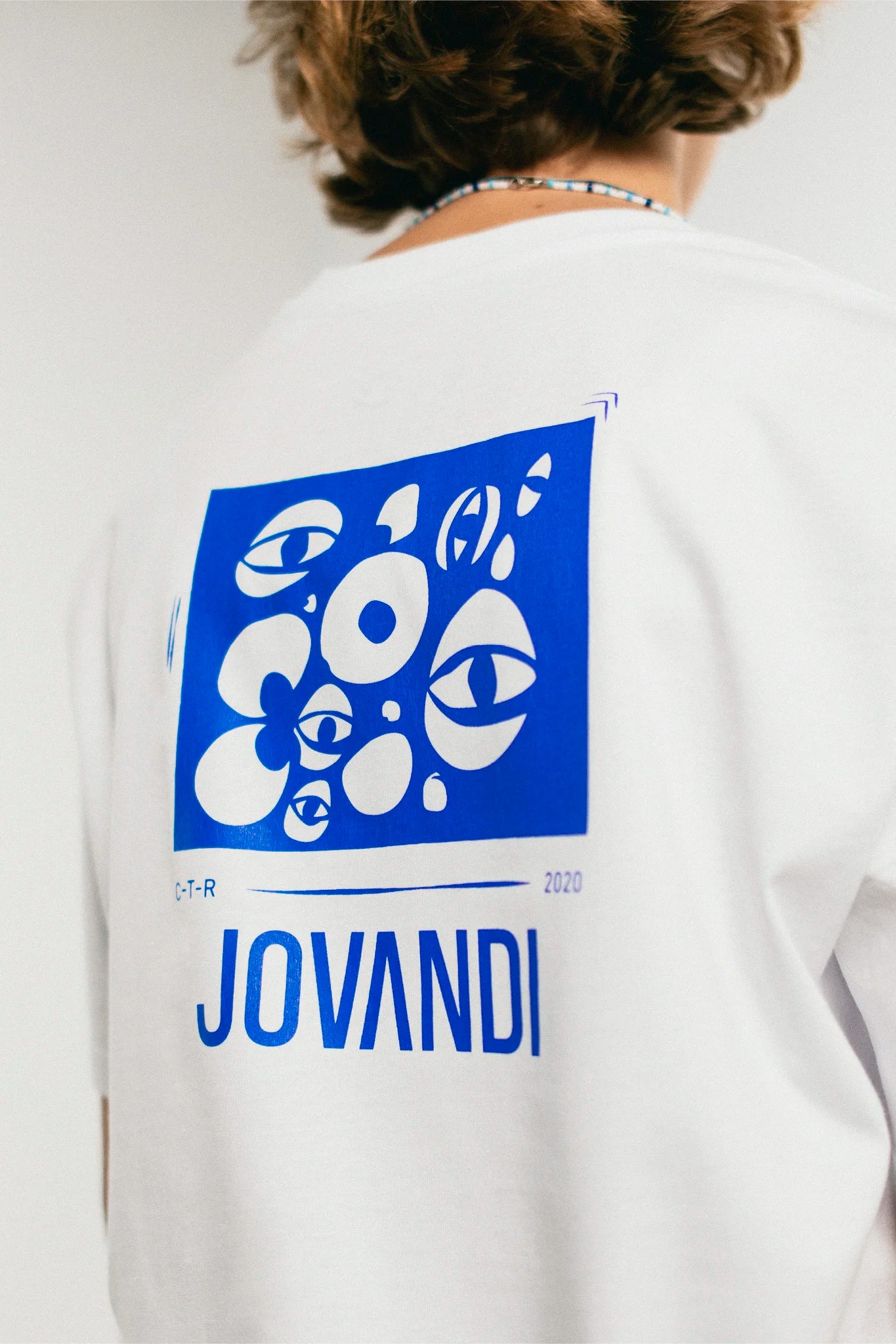 Woman wearing the white and blue Jovandi Cheyes1 T-Shirt