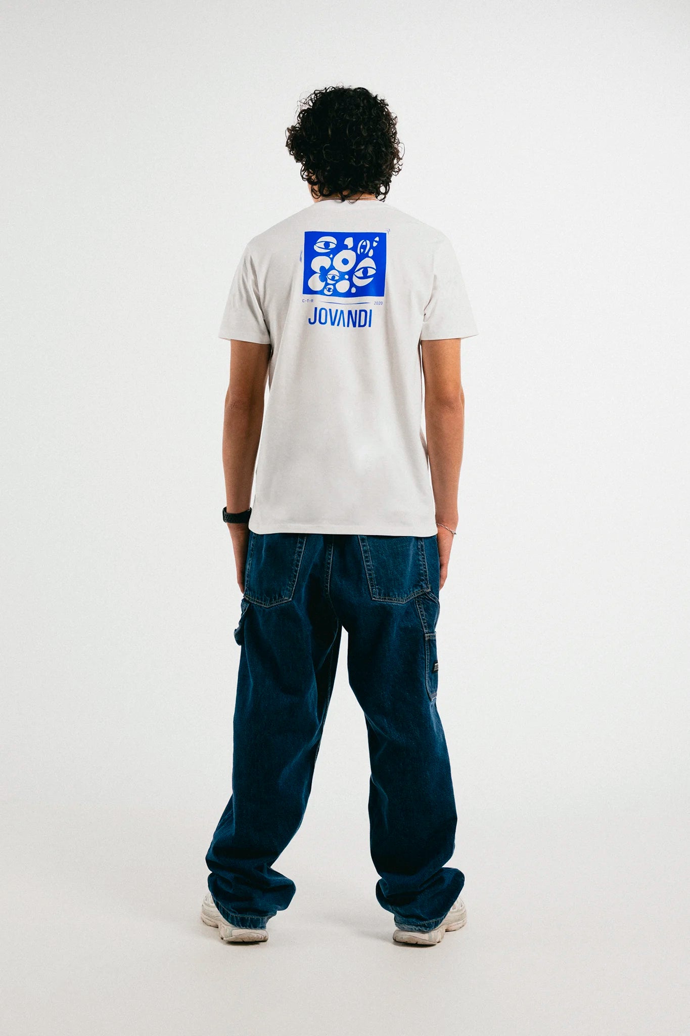 Man wearing the white and blue Jovandi Cheyes1 T-Shirt