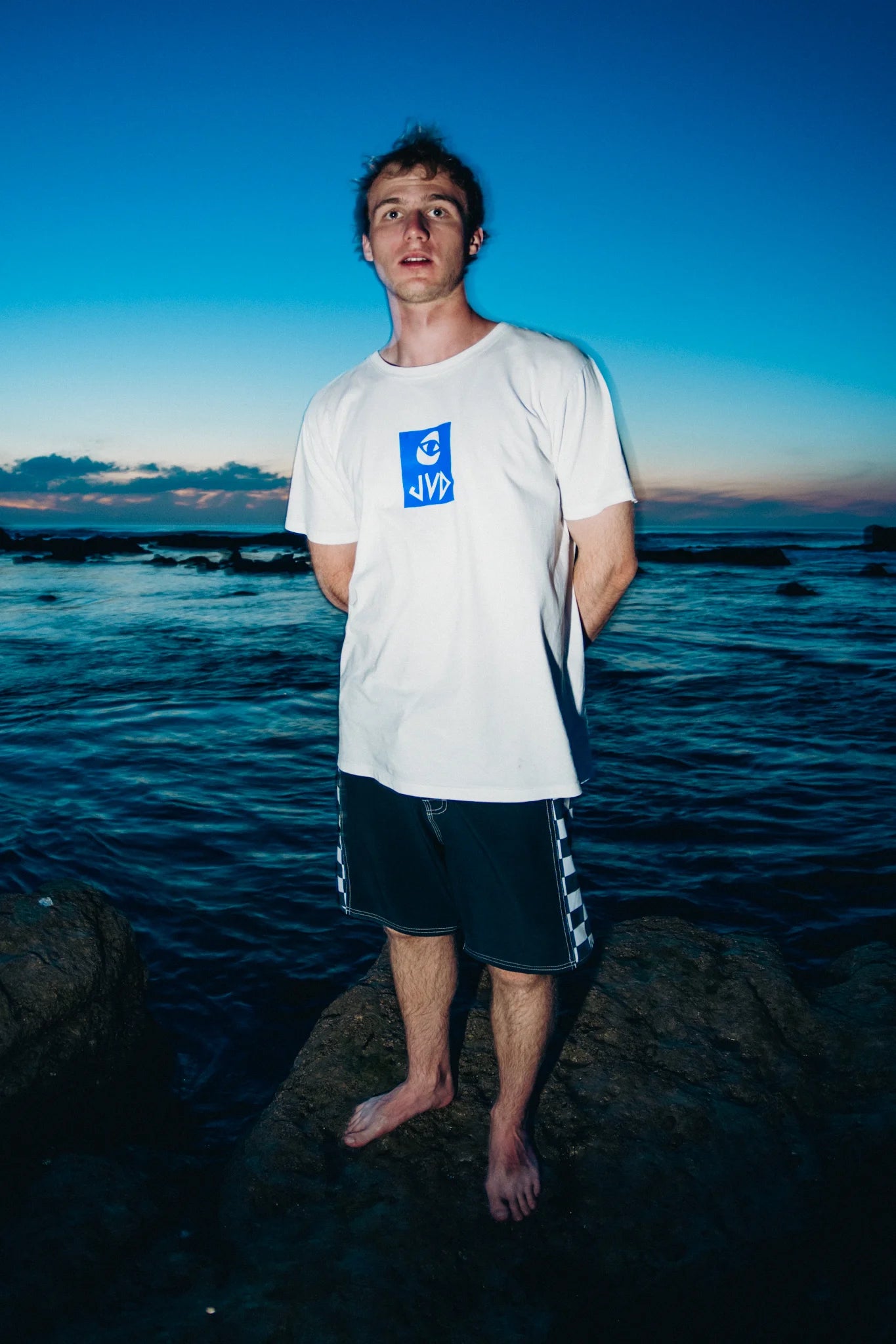 Dude with a white Jovandi Cheyes2 T-Shirt at sunset on a beach in france