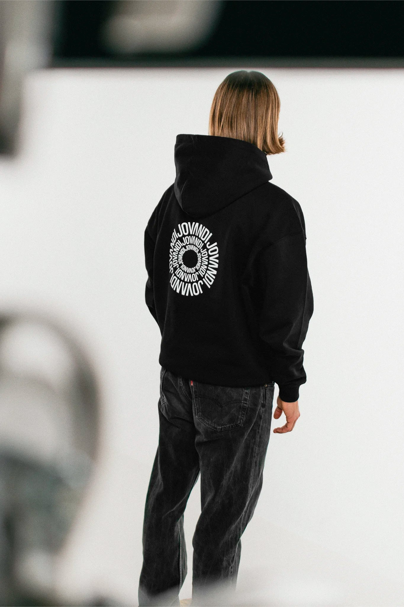 Man wearing the black Jovandi circle hoodie