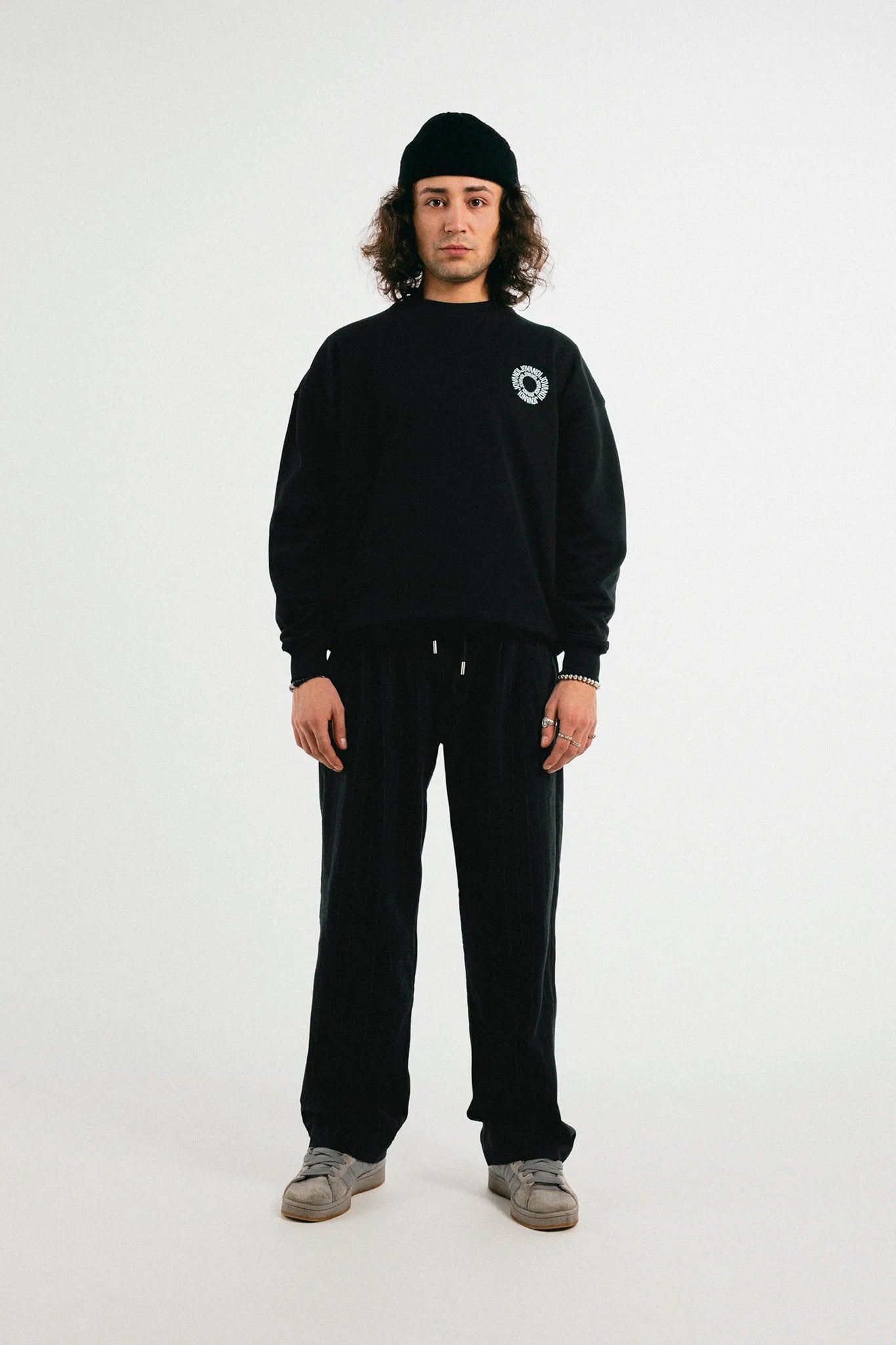 Man with the black Jovandi Circle sweater in front of a white backdrop