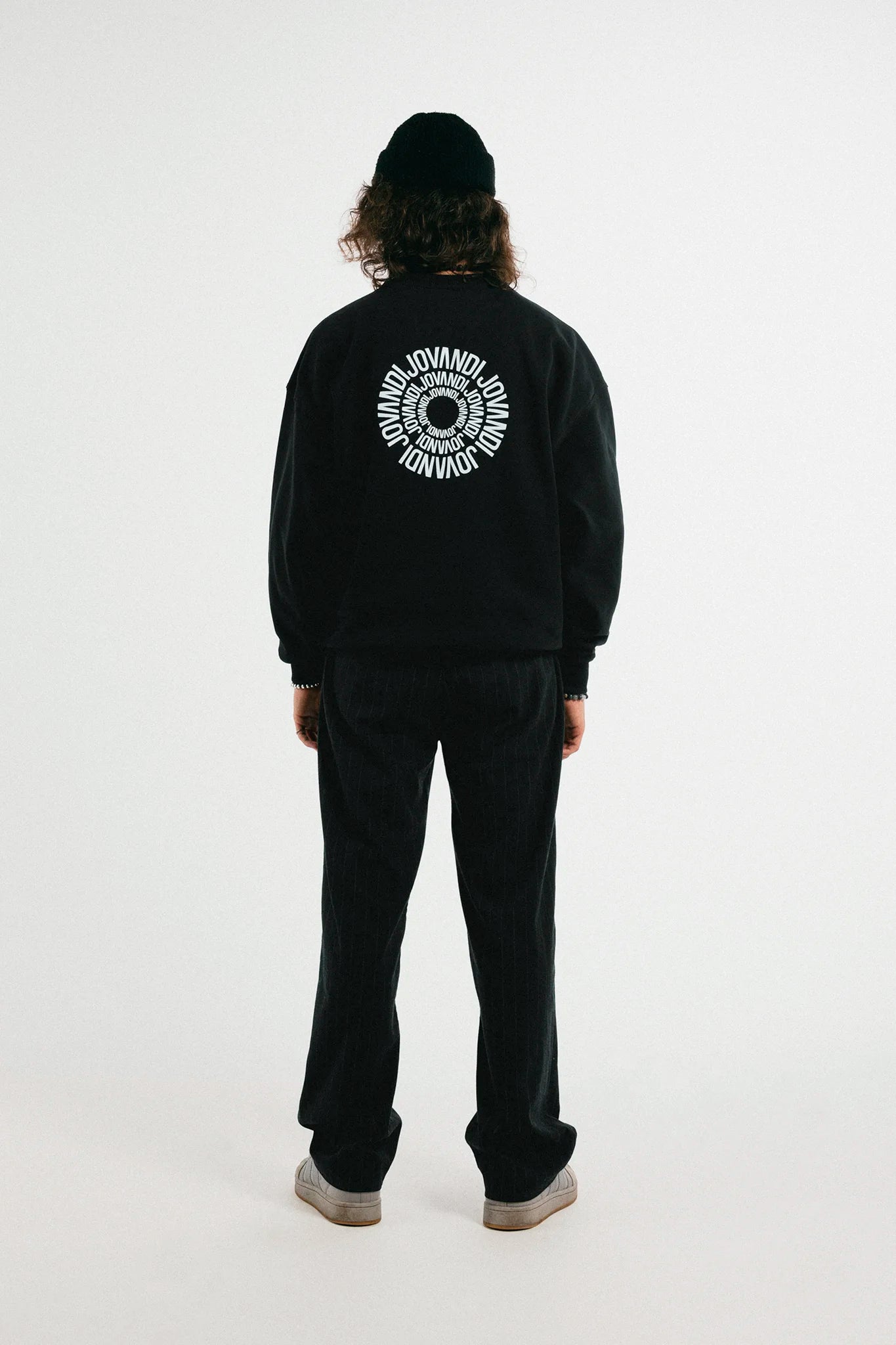 Man with the black Jovandi Circle sweater in front of a white background