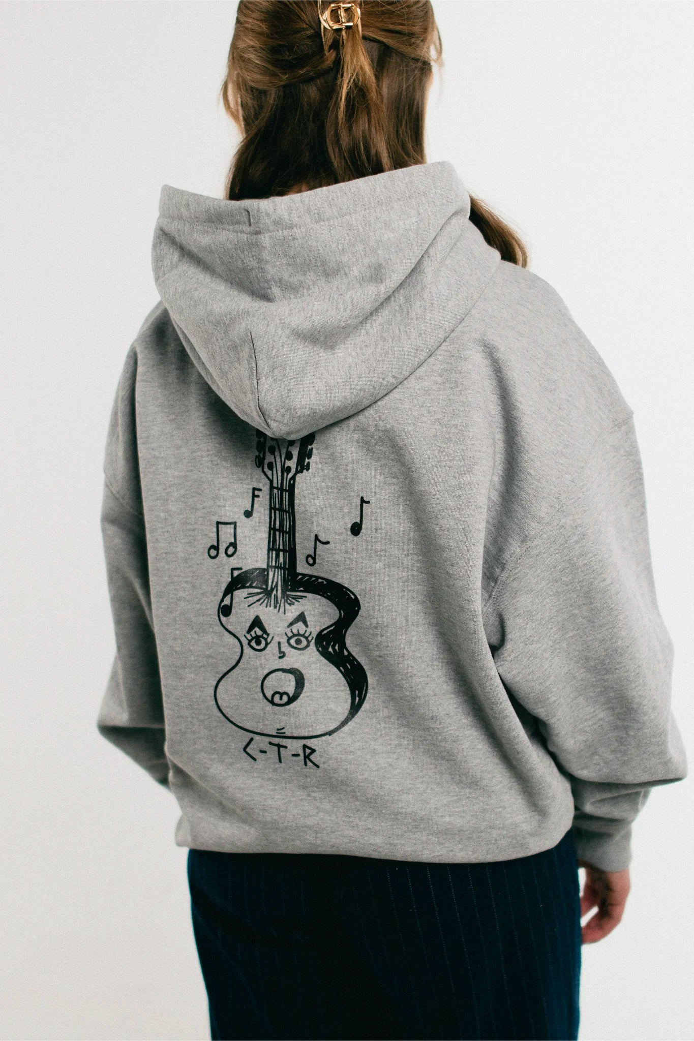 Woman wearing the heather grey Jovandi Guitar Hoodie
