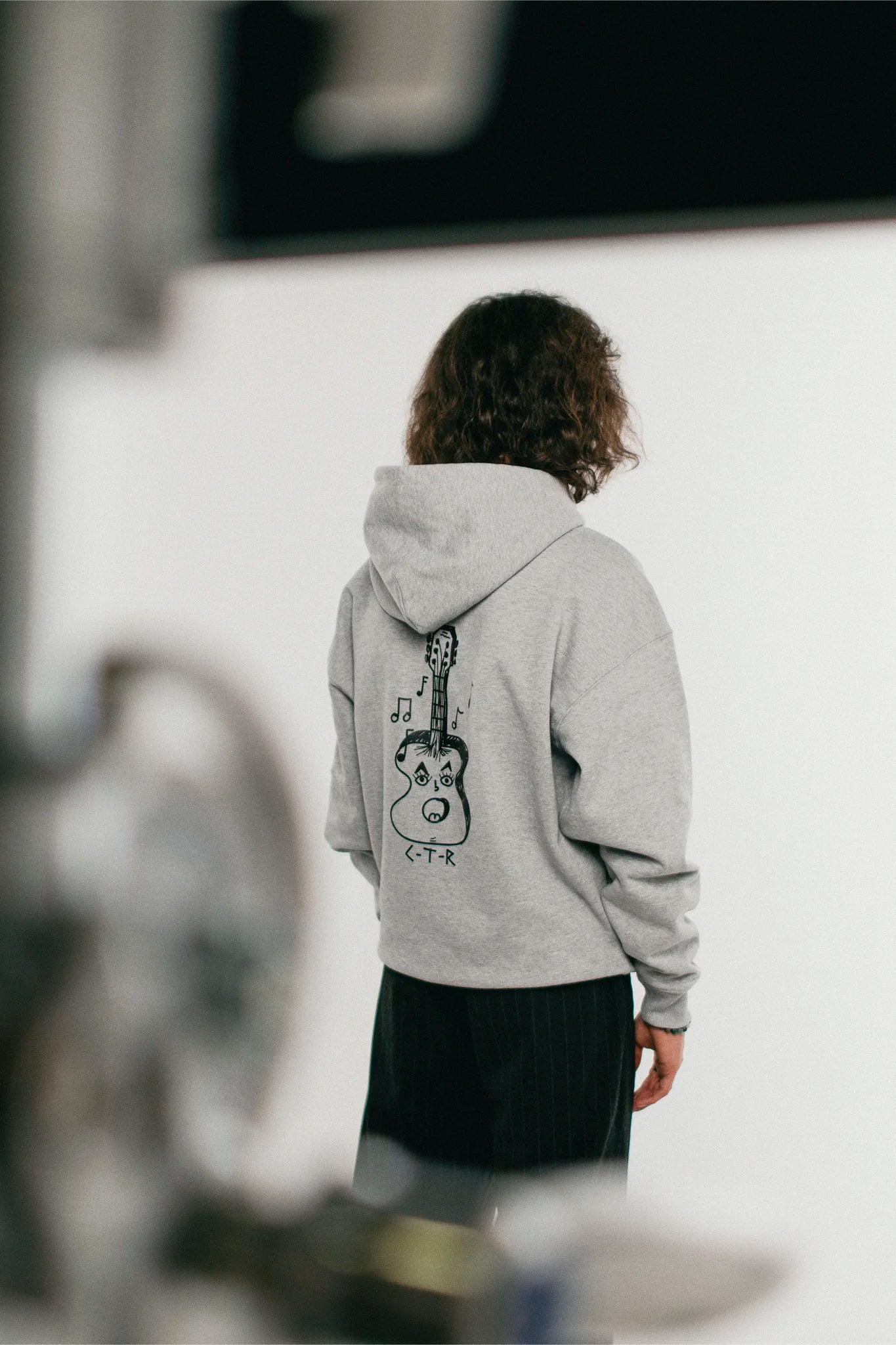 man wearing the heather grey Jovandi guitar hoodie