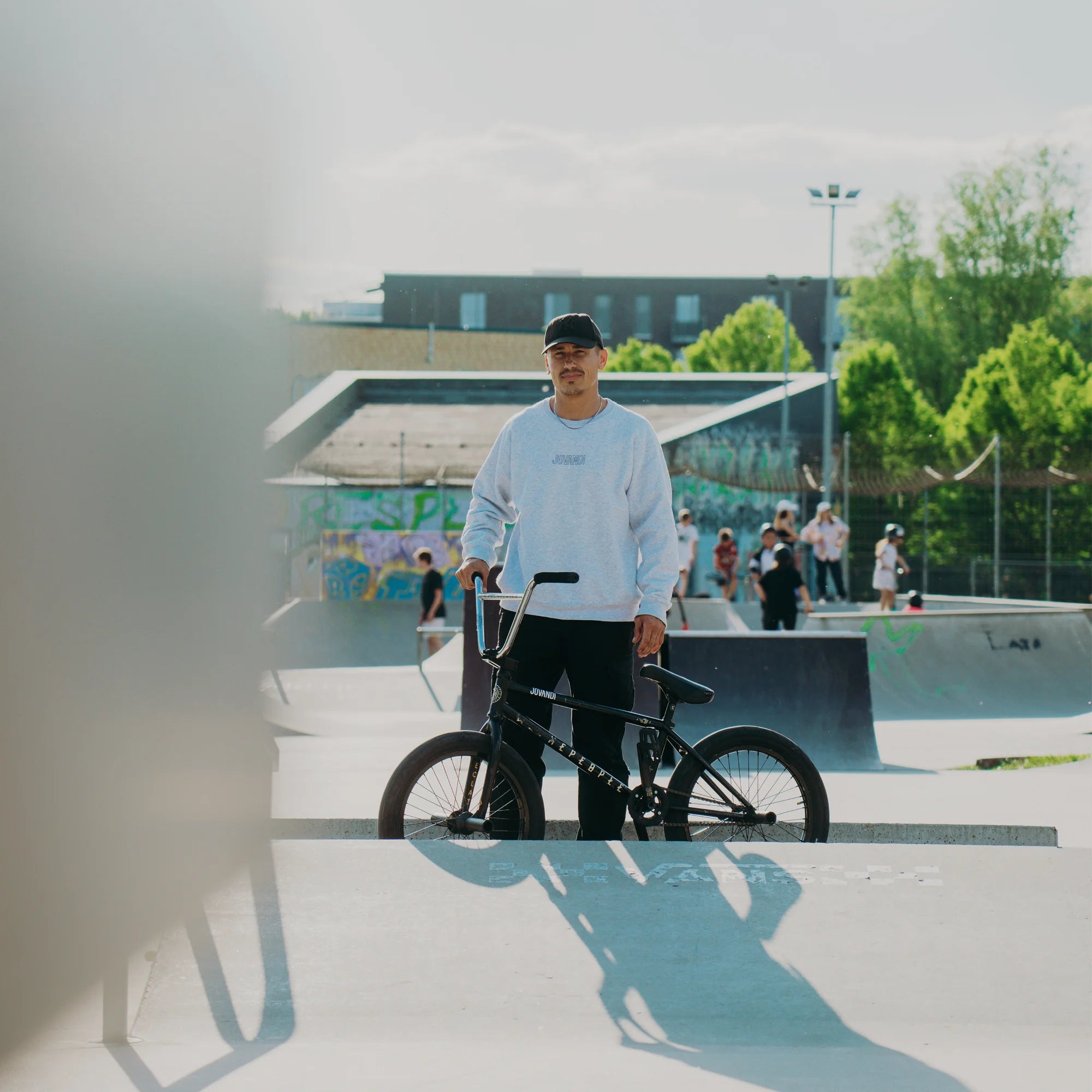Man wearing the heather grey Jovandi lines sweater on a sunny day at the skatepark allerfornia in Hamburg Allermöhe