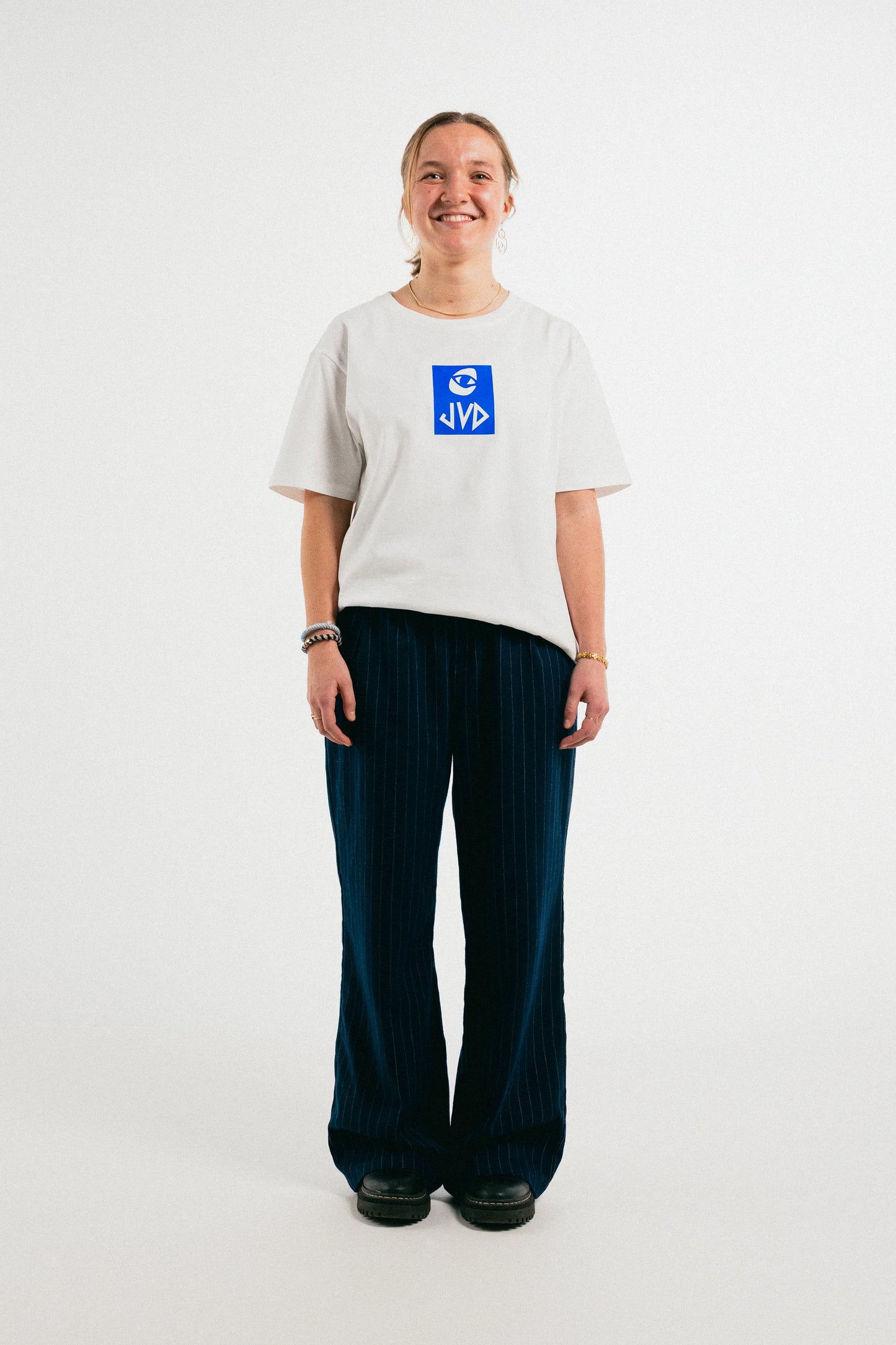 Smiling woman wearing the white Jovandi Cheyes One T-Shirt