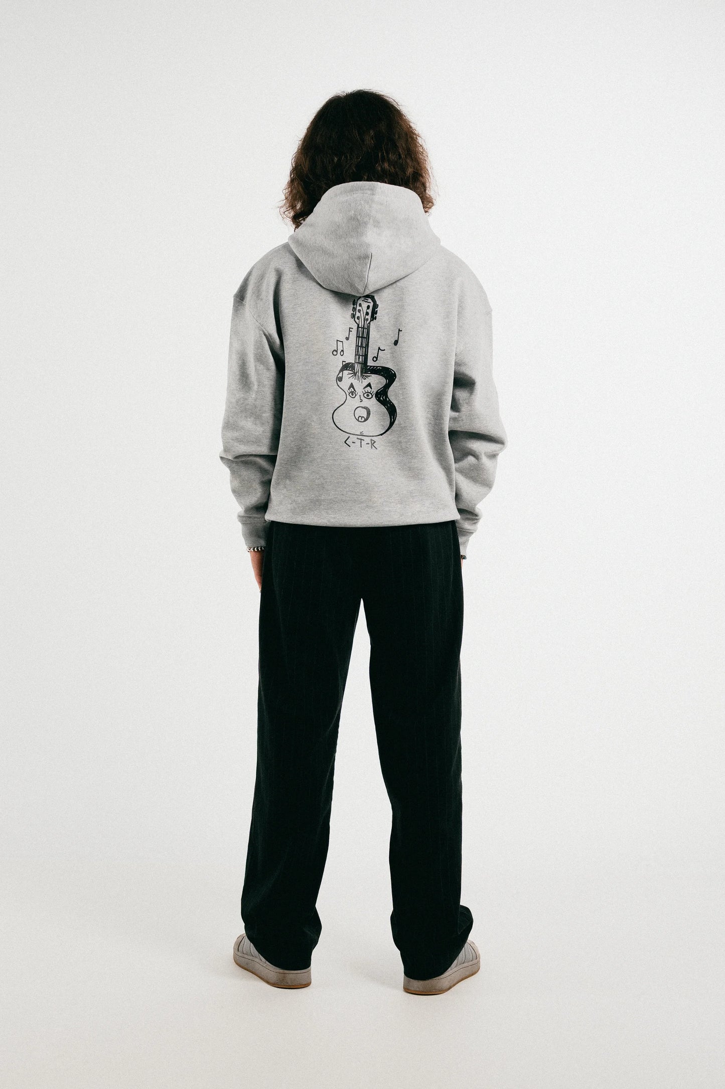 Man wearing the heather grey Jovandi Guitar hoodie