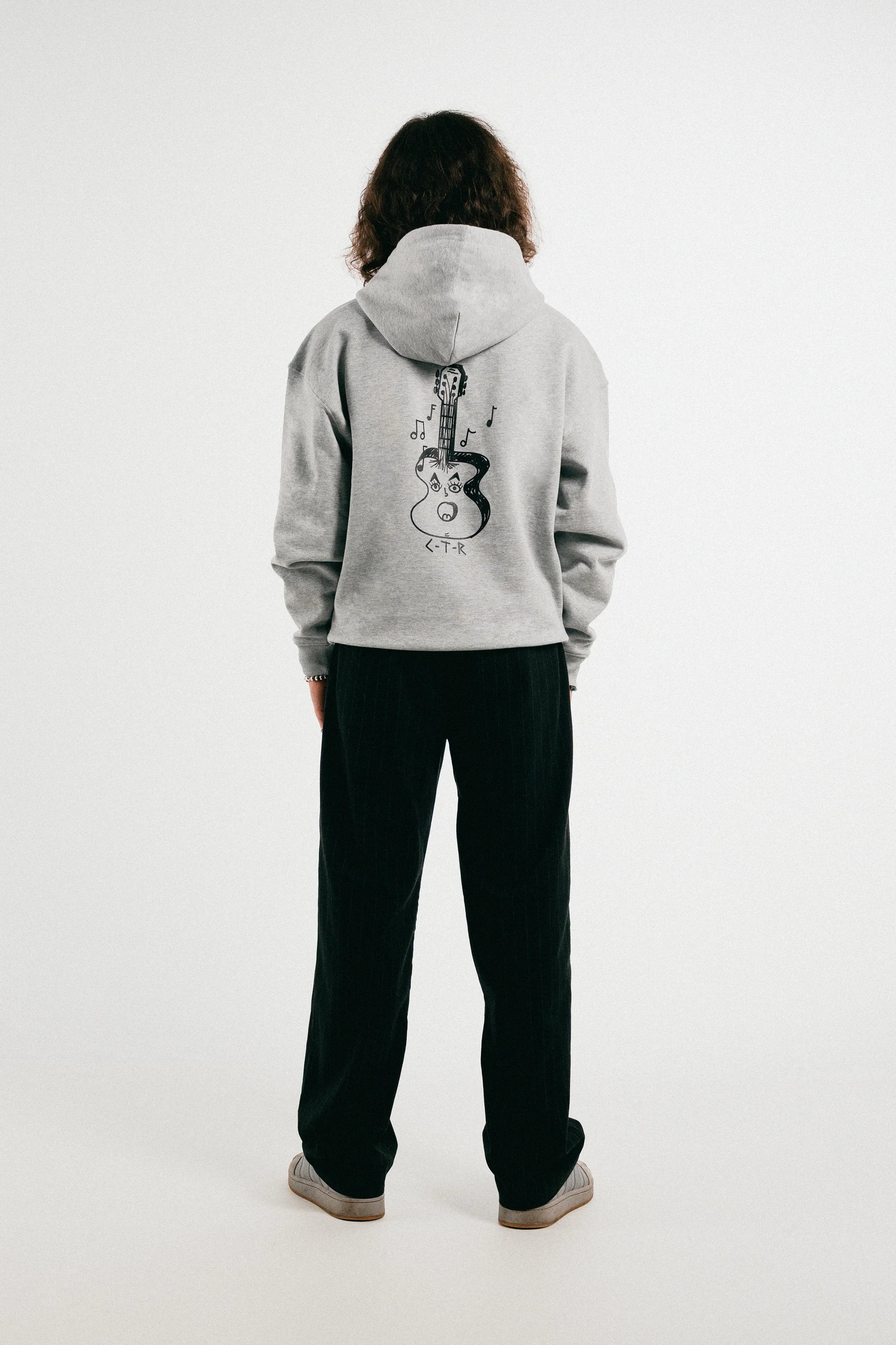 Man wearing the heather grey Jovandi Guitar hoodie
