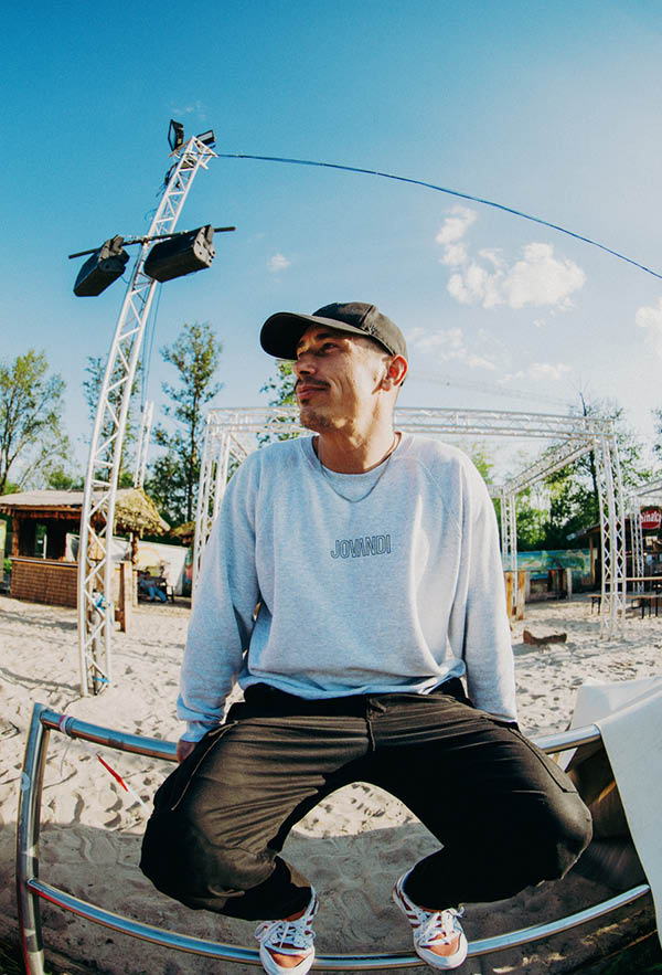 A guy wearing the lines sweater at a beach section of the skatepark allerfornia