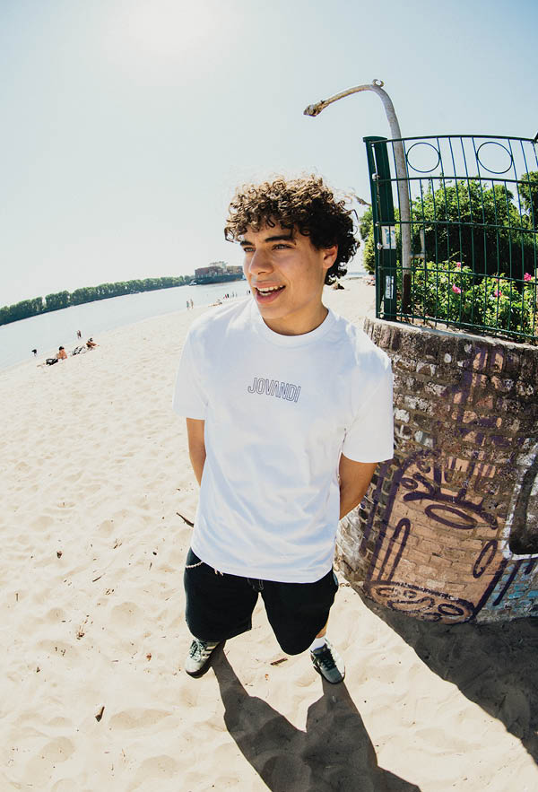 A guy standing on the beach with the lines tshirt from the front