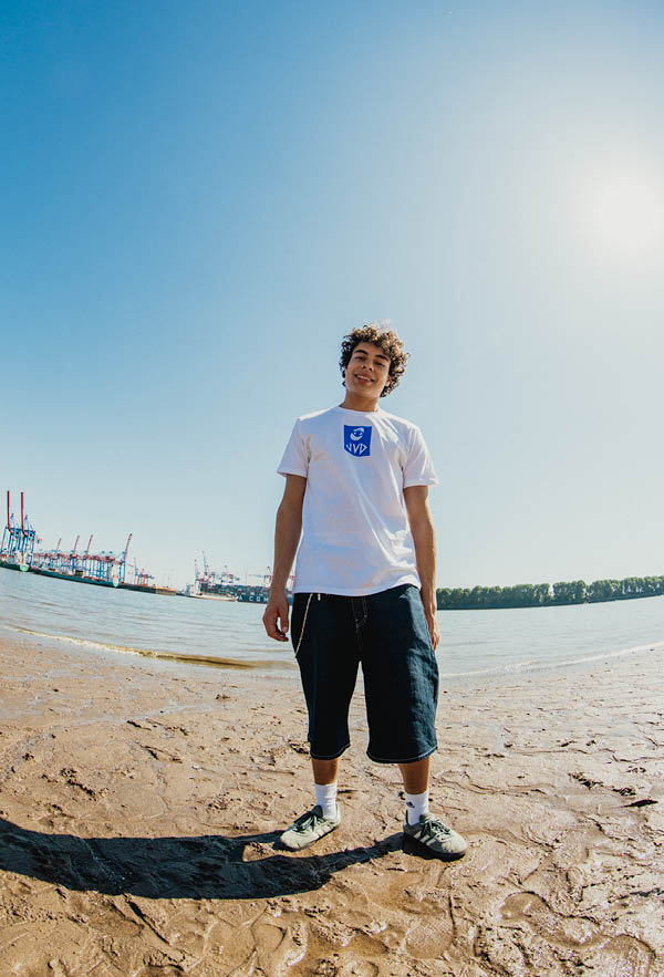a dude smiling in the camera on the beach wearing the cheyes 2 tshirt