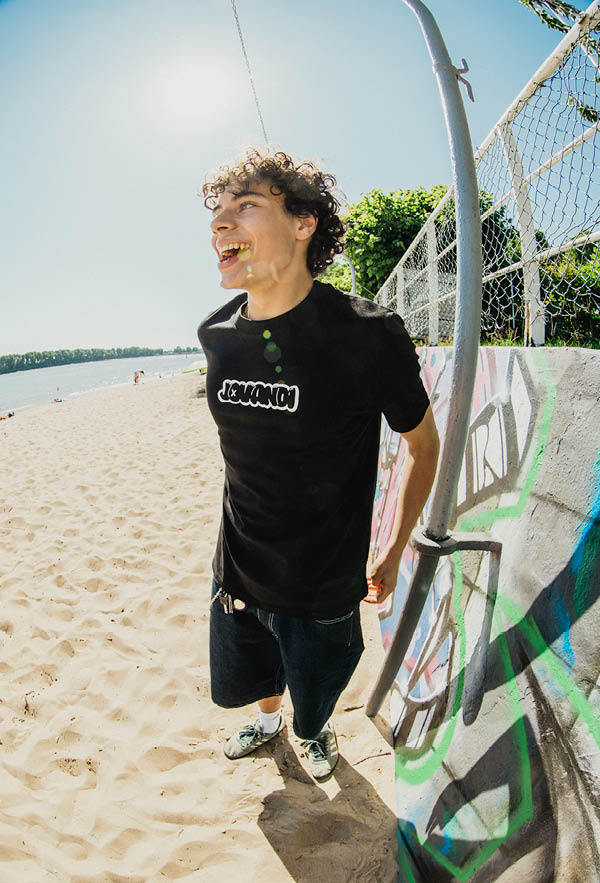 a boy smiling on the beach wearing the bouble tshirt