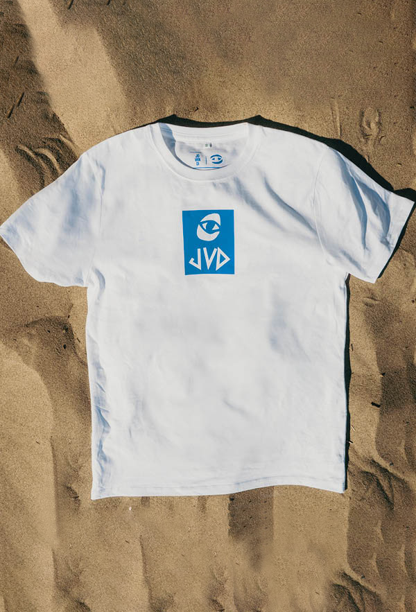 a flatlay of the cheyes 2 tshirt on the sand