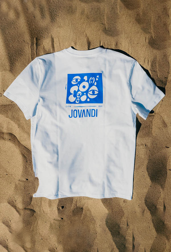 a flatlay of the cheyes 1 tshirt on the sand