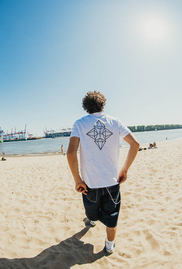 A guy walking on the beach with the diamonds tshirt