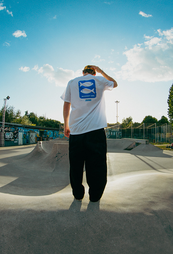 A boy wearing the HH Street Jam TShirt at sunset in a skatepark