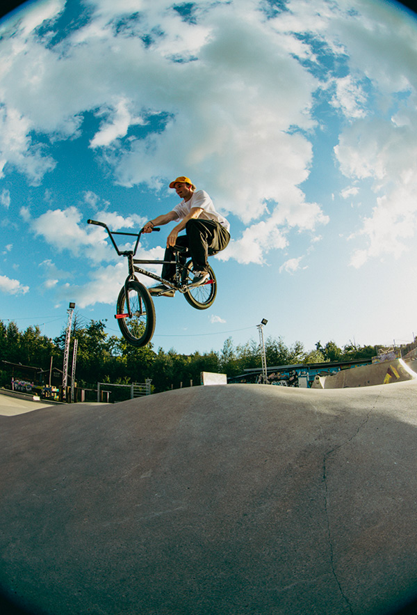 A boy wearing the HH Street Jam TShirt at sunset in a skatepark