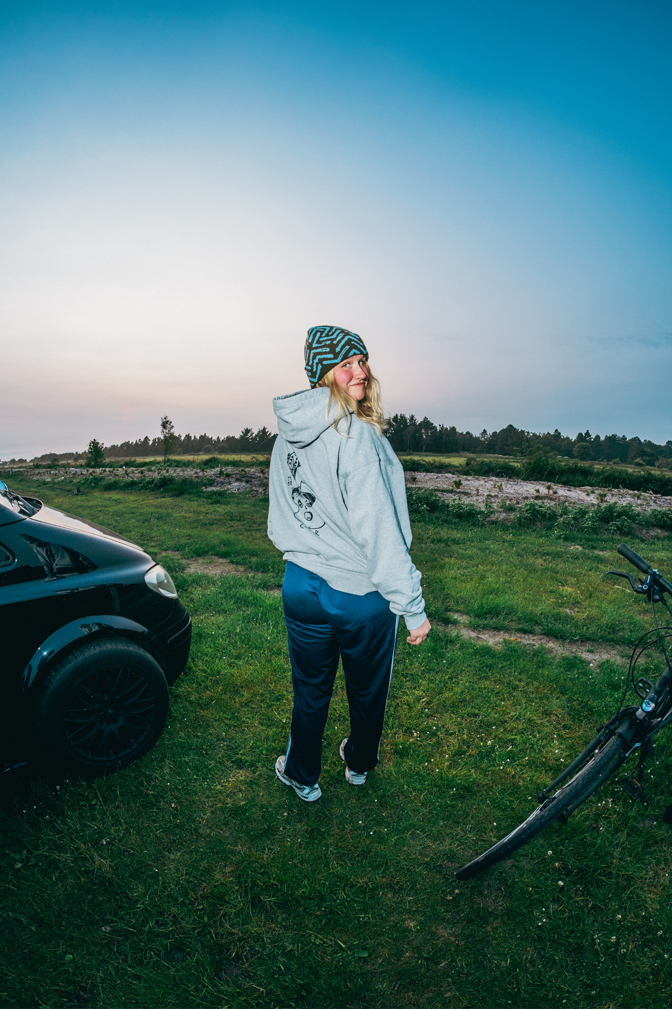A girl wearing the guitar hoodie at sunset